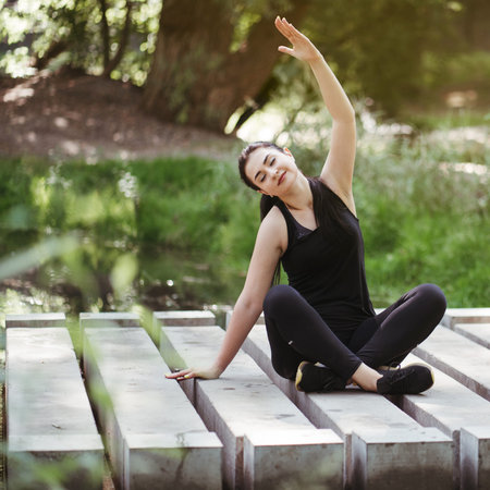 Young woman meditating in the park doing yoga