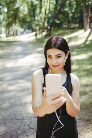 Fit woman with smart phone in the streetの写真素材