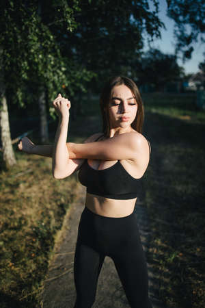 Fit woman stretching hands during outdoor trainingの写真素材