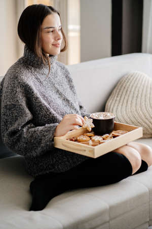 Woman eating festive sweets with hot chocolateの写真素材