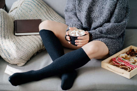 Warming hygge mood. Woman drinking hot chocolateの写真素材
