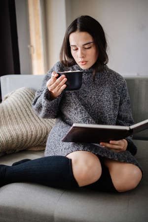 Woman enjoy hot chocolate and reading a bookの写真素材