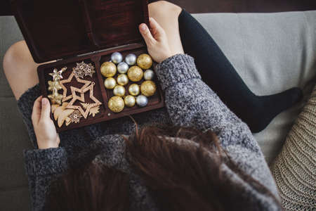 Woman opening box with Christmas embellishmentsの写真素材