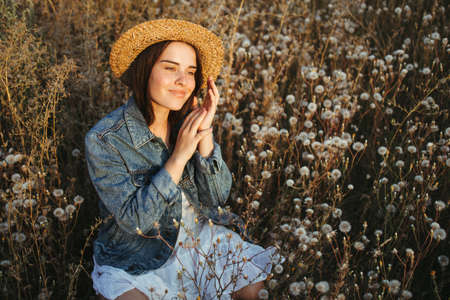 Woman on dandelion field in sunset. Allergicの写真素材