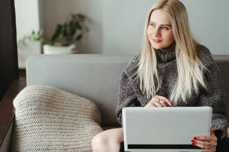 Online shopping, remote work and study. Woman using laptop in cozy living room. Holiday sale...
