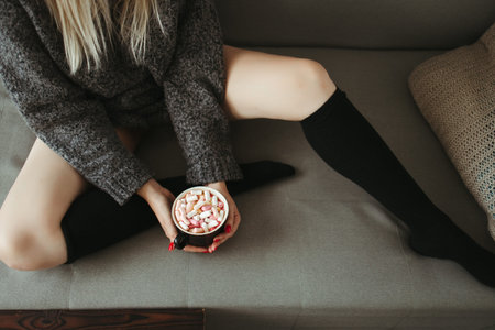 Christmas, cold autumn or winter day. Warming mood. Woman drinking warm cocoa with marshmallows....