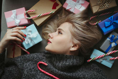 Sale and shopping. Christmas, New Year, winter holidays festivity and celebration concept. Cute young woman with many present boxes. Family, love, surprise and joyの写真素材