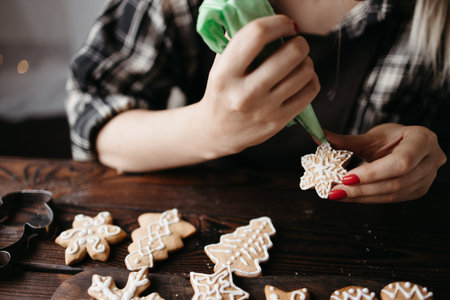 Christmas and New Year celebration traditions. Confectioner decorating gingerbread cookies. Winter...