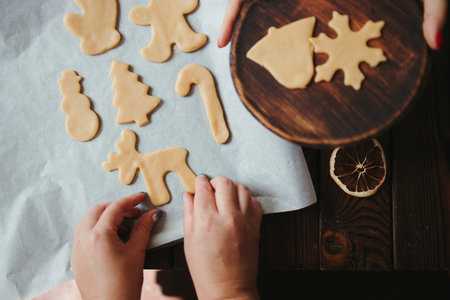 Christmas bakery. Confectioner holding pastry board with raw gingerbread cookies before baking....