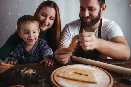 Christmas time, family love. Home weekend. Winter holidays. Family making Christmas gingerbread cookies togetherの写真素材