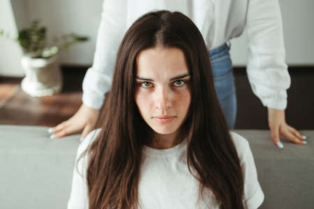 Support, conflict, quarrel, human relationships. Young woman with her opponent in living roomの写真素材