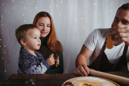 Christmas time, family love. Home weekend. Winter holidays. Family making Christmas gingerbread cookies togetherの写真素材