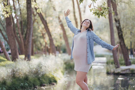 Happy motherhood, healthy pregnancy and active lifestyle. Pregnant woman walking outdoorsの写真素材