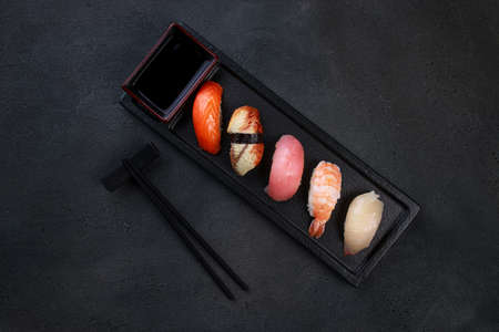 Sushi set. Delicious nigiri sushi on black plate, seafood background. Japanese food restaurant delivery menuの写真素材