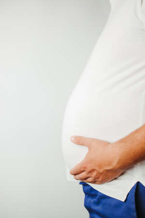 Diet, stress, eating problems, compulsive overeating, weight gain. Overweight man holding big belly, copy spaceの写真素材