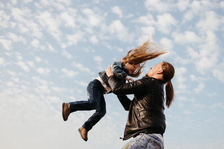 Cheerful father playing with little girl outdoors. Dad and daughter. Fatherhood, family conceptの写真素材