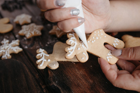Christmas sweets. Decorating freshly baked gingerbread cookies. Festive food, family culinary, celebrating traditions conceptの写真素材