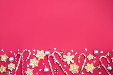 Christmas composition, New Year greeting card. Mockup with festive decorations and gingerbread cookies on red background. Copy spaceの写真素材