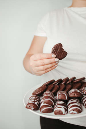 Weight loss, overweight, diet, unhealthy eating. Fat woman with plate of chocolate cookiesの写真素材