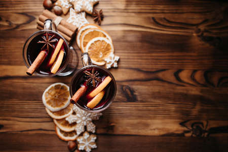 Christmas atmospheric background, home celebration. Hot mulled wine, spices and festive gingerbread cookies. Winter holidays celebration conceptの写真素材