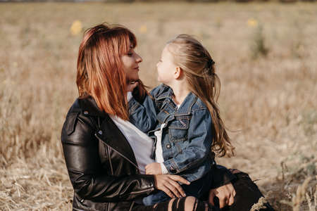 Mother and daughter. Motherhood, family concept. Loving mom walking outdoors spending time together with her little daughterの写真素材