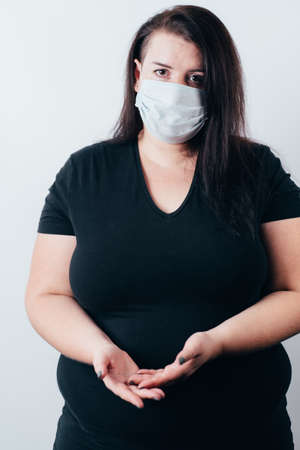 Helping hand, donation, support locals. Desperate woman in medical mask with cupped hands asking for helpの写真素材