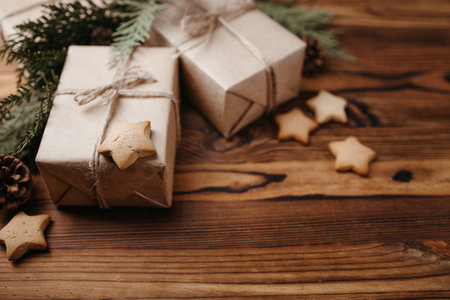 Christmas holiday concept, eco decor. Zero waste and eco-friendly embellishments. Gift boxes wrapped in craft paper, gingerbread and evergreen branchesの写真素材