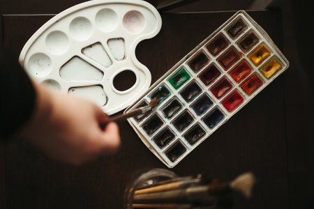 Artwork. Skilled artist mixing watercolor paints with brush, close up. Creative occupation, home leisure, hobby conceptの写真素材