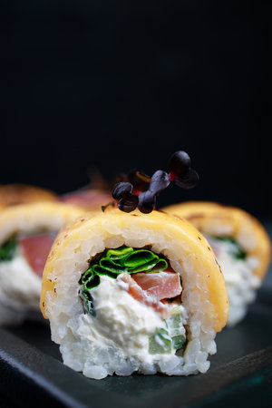 Seafood restaurant menu, professional culinary, Japanese food art. Tuna and cheese sushi rolls set served on plate, close upの写真素材