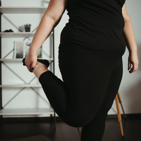 Home workout. Overweight woman doing stretching exercises in her living room. Weight loss, activity and healthy lifestyleの写真素材