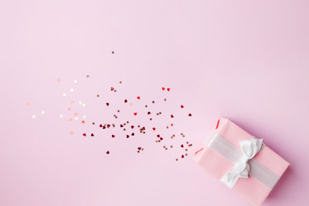 Valentine's, Mother's or Women's Day holidays preparations. presents, celebration concept. composition with gift box and sparkles on pink backgroundの写真素材