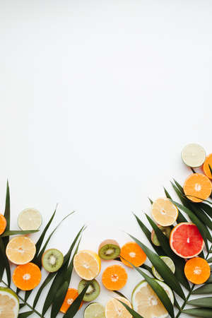 Summer vibes. Composition with exotic fruits on white background. Summertime vacation, cocktail, tropical beach. Creative fruity layout, copy spaceの写真素材