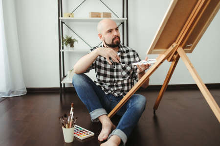 Creative home leisure. Man does easel drawingの写真素材