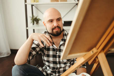 Young man doing watercolor painting at home studioの写真素材