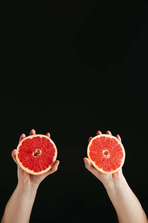 Diet decision and nutrition choice, healthy good fresh halved grapefruit in woman hands, copy spaceの写真素材