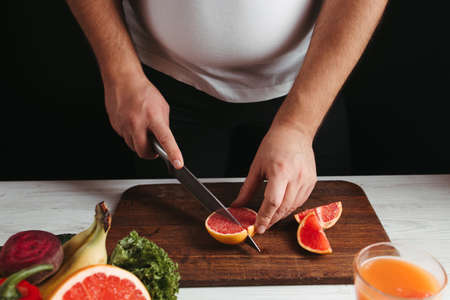 Diet concept, healthy lifestyle, low calorie food. Overweight woman cooking healthy dinner of fresh juicy fruitsの写真素材