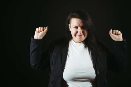 Happiness, victory, success and achievement concept. Happy joyful smiling woman making a win gesture over black background,の写真素材