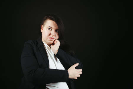 Bored unimpressed disinterested woman over black background. Low mood, boredom, no idea conceptの写真素材