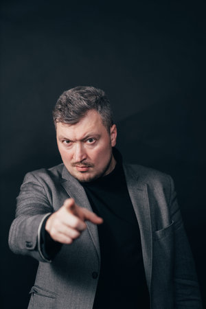 Businessman pointing finger looking at camera