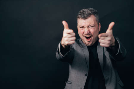 Excited businessman pointing fingers at cameraの写真素材