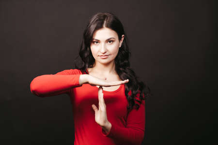 Confident woman showing T sign with handsの写真素材