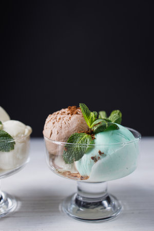 Ice-cream scoops variety in glass sundae bowlsの写真素材