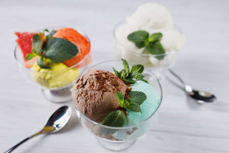 Set of ice cream scoops in glass sundae bowlsの写真素材