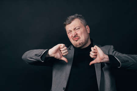 Man express rejection with thumbs down gestureの写真素材