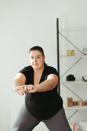 Overweight woman doing physical exercises at homeの写真素材