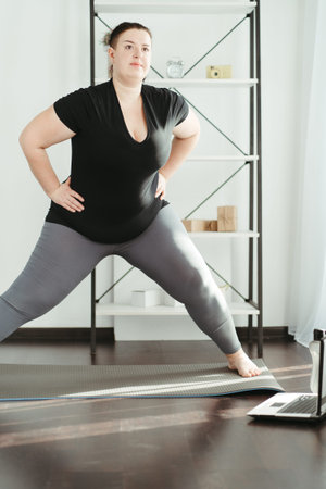 Overweight woman doing physical exercises at home