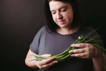Vegetarian woman holding fresh greenery in handsの写真素材