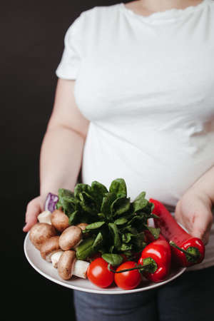 Healthy vegetarian food. Fat woman with vegetablesの写真素材
