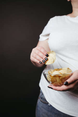 Overweight woman eat unhealthy fattening junk foodの写真素材