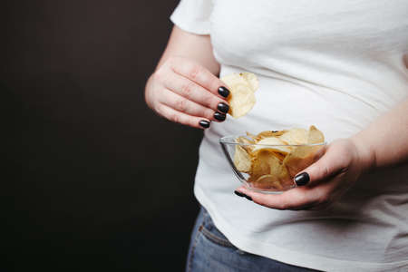 Overweight woman eat unhealthy fattening junk foodの写真素材